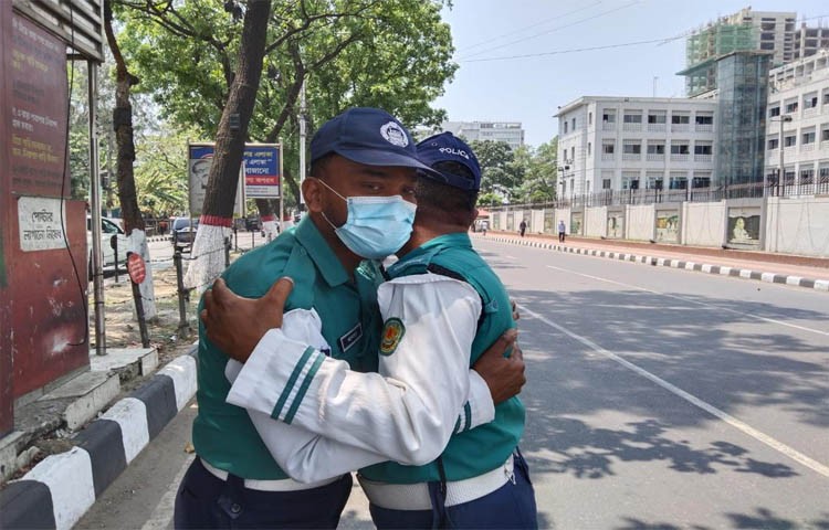 প্রখর রোদে দাড়িয়ে, ট্রাফিকের হাতের ইশারায় ঈদে ঘর মুখো যাত্রীদের যাত্রা নিরাপদ ও যানবাহনের চাপ সামলাতে,ট্রাফিক বিভাগের অধিকাংশ সদস্য পরিবার বিহীন সড়কেই  হাসি মুখে দ্বায়িত্ব পালন করেন,অফিস খোলার পর,সচিবালয়ের সামনে দুজন ট্রাফিক সদস্যদের কুশল বিনিময়। ছবি আজ সোমবার সচিবালয় এলাকা থেকে তোলা - এস এ মাসুম