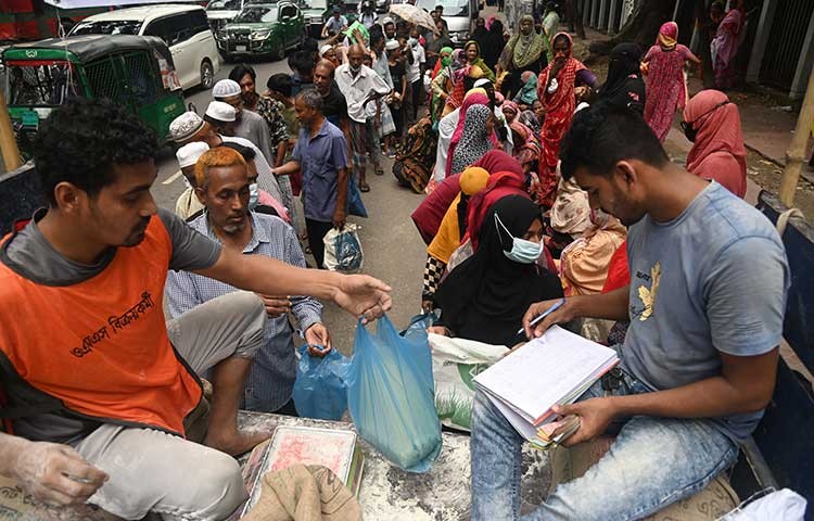 আজ মঙ্গলবার ওএমএস এর চাল আটা কিনতে নিম্ন আয়ের মানুষের দীর্ঘ লাইন। ছবি - এস এ মাসুম