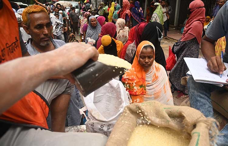 আজ মঙ্গলবার ওএমএস এর চাল আটা কিনতে নিম্ন আয়ের মানুষের দীর্ঘ লাইন। ছবি - এস এ মাসুম